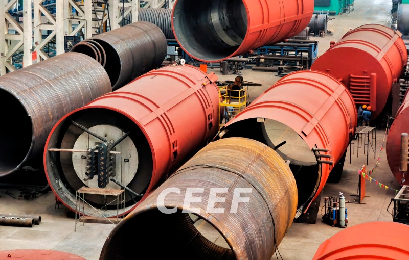 Large helical radiant coils being rolled and assembled into the furnace bodies of CEEF ultra-large thermal oil heaters on the factory floor